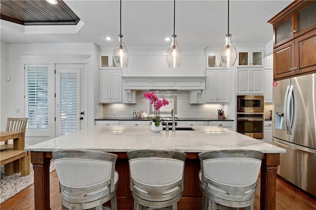 16305 Flint St, Overland Park, KS 66221 - kitchen featuring stainless steel appliances, a sink, dark wood-type flooring, backsplash, and light stone countertops