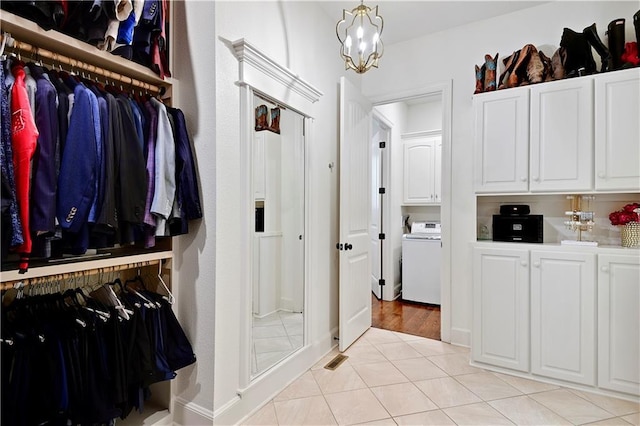 16305 Flint St, Overland Park, KS 66221 - walk in closet with washer / clothes dryer, a chandelier, and light tile patterned floors