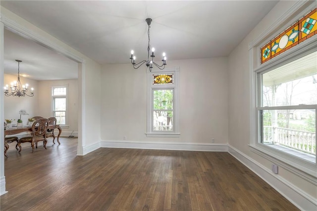 interior space featuring an inviting chandelier, dark wood-style flooring, and baseboards