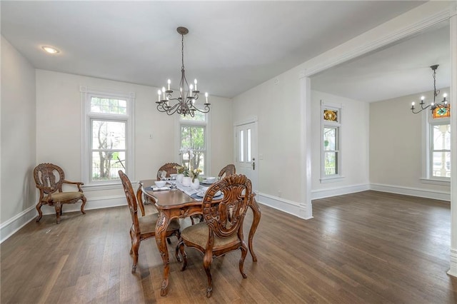dining room featuring a chandelier, baseboards, dark wood-style flooring, and plenty of natural light