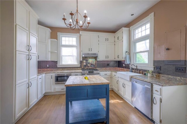 kitchen with open shelves, a sink, stainless steel appliances, under cabinet range hood, and backsplash