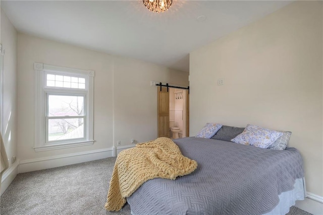 bedroom featuring a barn door, carpet flooring, and baseboards