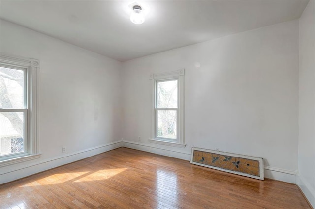spare room featuring hardwood / wood-style floors and baseboards