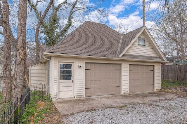 detached garage featuring fence