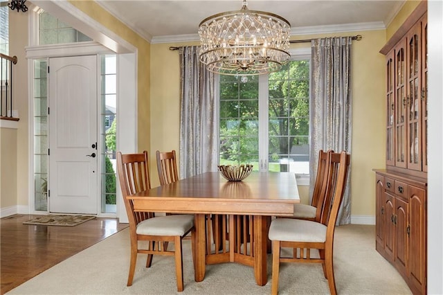 dining space featuring a chandelier, plenty of natural light, baseboards, and crown molding