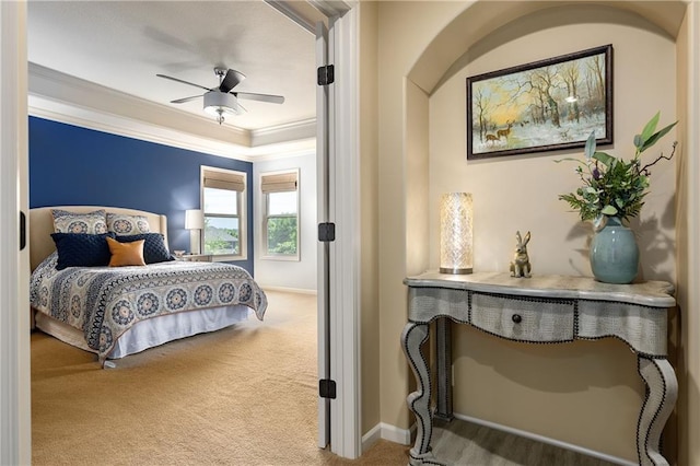 carpeted bedroom featuring crown molding, baseboards, and a ceiling fan
