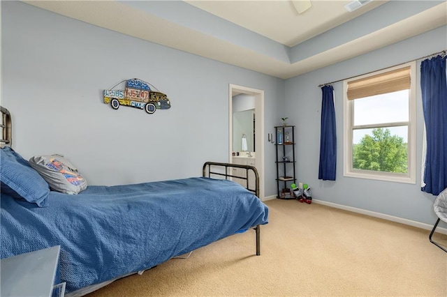 carpeted bedroom with baseboards and a tray ceiling