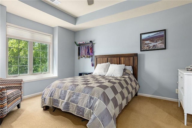 bedroom with light colored carpet, baseboards, and a ceiling fan
