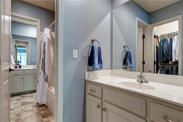 full bathroom with vanity and a spacious closet