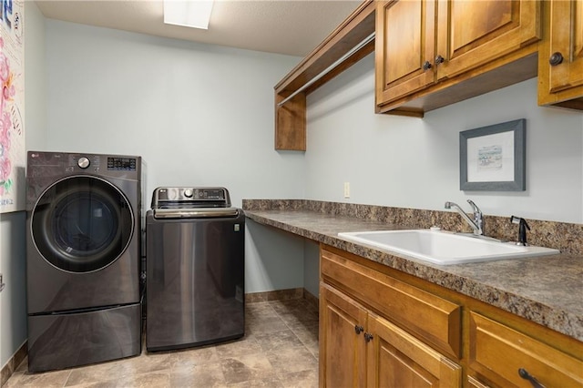 washroom featuring separate washer and dryer, cabinet space, and baseboards