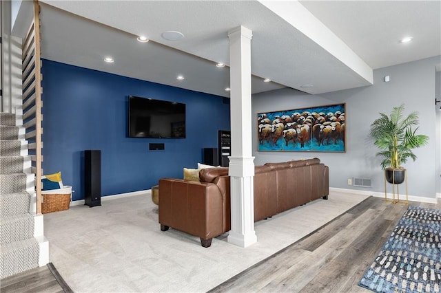 living room featuring stairs, decorative columns, baseboards, wood finished floors, and recessed lighting