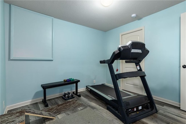 workout area featuring wood finished floors and baseboards