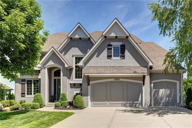 10804 W 169th St, Overland Park, KS 66221 - view of front facade featuring concrete driveway, a front yard, stucco siding, and an attached garage