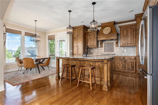 10804 W 169th St, Overland Park, KS 66221 - kitchen featuring appliances with stainless steel finishes, custom range hood, brown cabinetry, baseboards, and ornamental molding