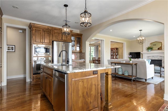 10804 W 169th St, Overland Park, KS 66221 - kitchen featuring stainless steel appliances, arched walkways, a chandelier, brown cabinetry, and crown molding