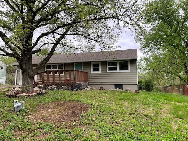 rear view of house featuring fence and a wooden deck
