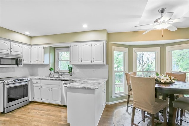 15819 W 147th Ter, Olathe, KS 66062 - kitchen with appliances with stainless steel finishes, a sink, white cabinets, light wood-style flooring, and recessed lighting