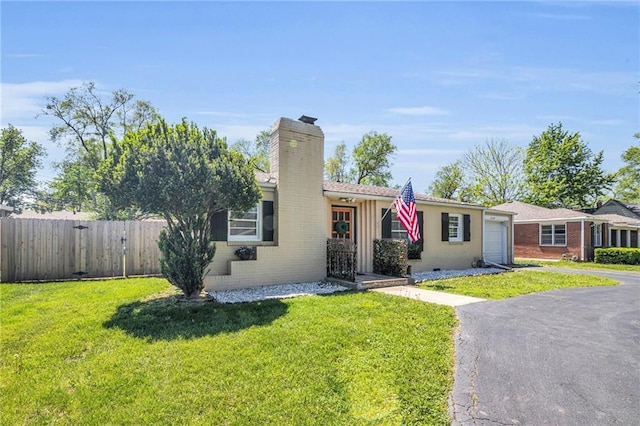 ranch-style house with an attached garage, fence, a chimney, and a front lawn