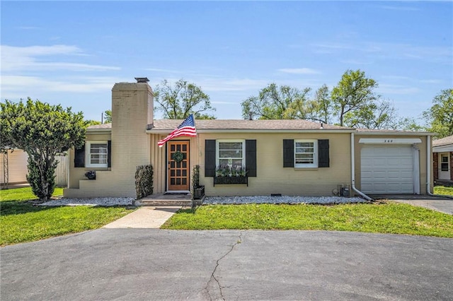 ranch-style house featuring an attached garage, a front yard, driveway, and a chimney