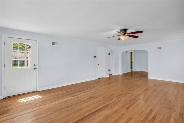 unfurnished living room featuring visible vents, arched walkways, light wood finished floors, and ceiling fan