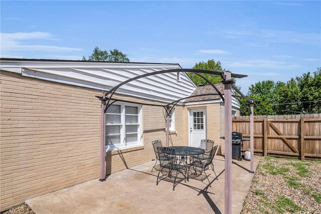 view of patio / terrace with fence, outdoor dining area, and a grill