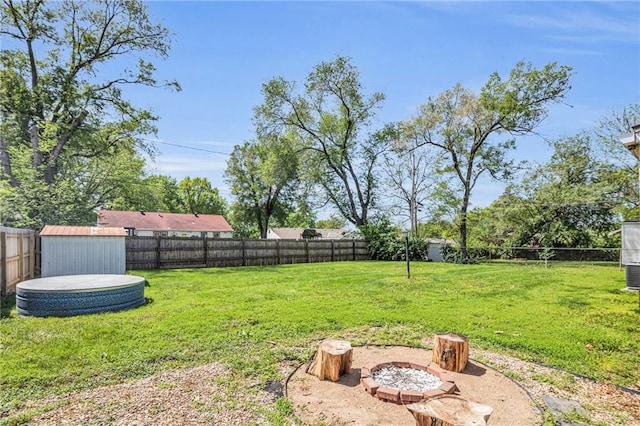 view of yard with a fenced backyard, an outdoor structure, and a shed