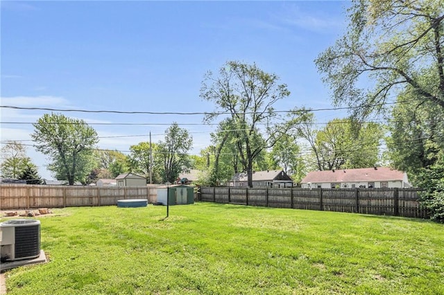 view of yard with a fenced backyard, a shed, an outbuilding, and cooling unit