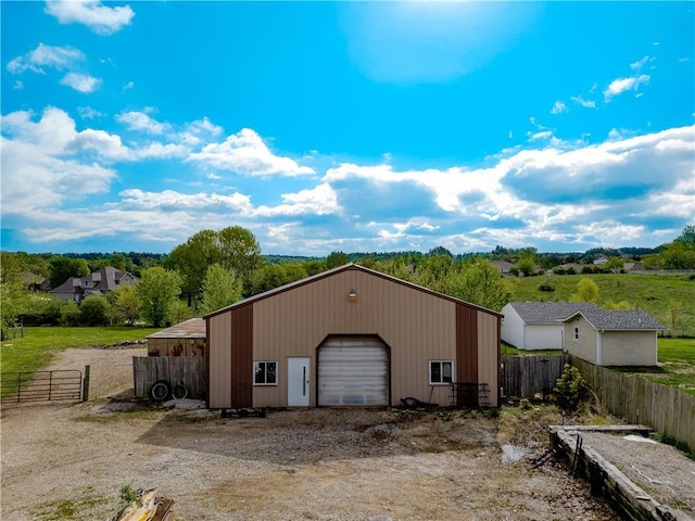 exterior space with fence, an outbuilding, a pole building, and a garage