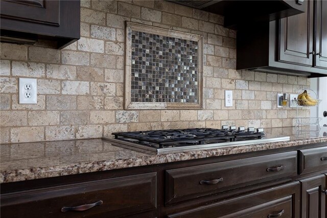 13017 Kelli Dr, Kearney, MO 64060 - kitchen with dark brown cabinets, stainless steel gas stovetop, tasteful backsplash, and light stone counters