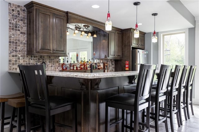 13017 Kelli Dr, Kearney, MO 64060 - indoor wet bar with healthy amount of natural light, freestanding refrigerator, decorative backsplash, and recessed lighting