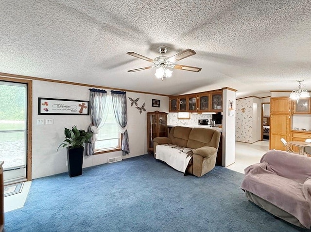 living area featuring ceiling fan with notable chandelier, visible vents, light carpet, and a healthy amount of sunlight