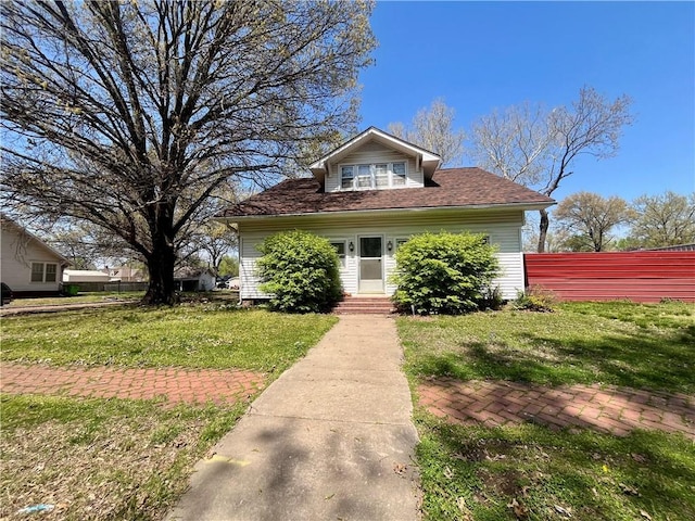 bungalow-style home featuring fence and a front lawn