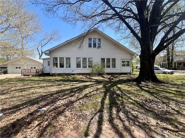 rear view of property with a garage and an outdoor structure