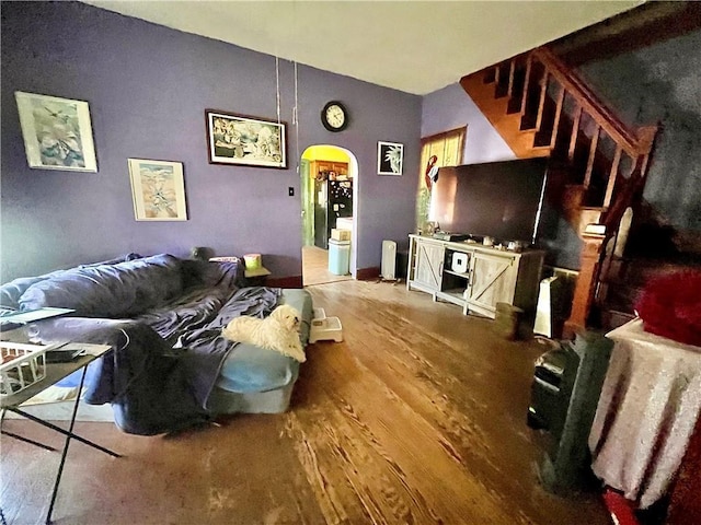 living area featuring wood finished floors and arched walkways