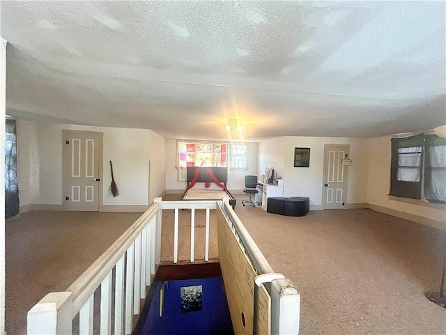 playroom featuring baseboards, carpet floors, and a textured ceiling