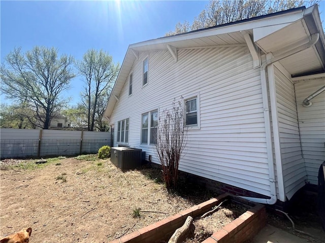 view of side of property featuring fence and central AC unit