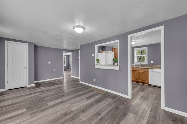 5315 Hardy Ave, Raytown, MO 64133 - unfurnished living room featuring a sink, baseboards, and wood finished floors