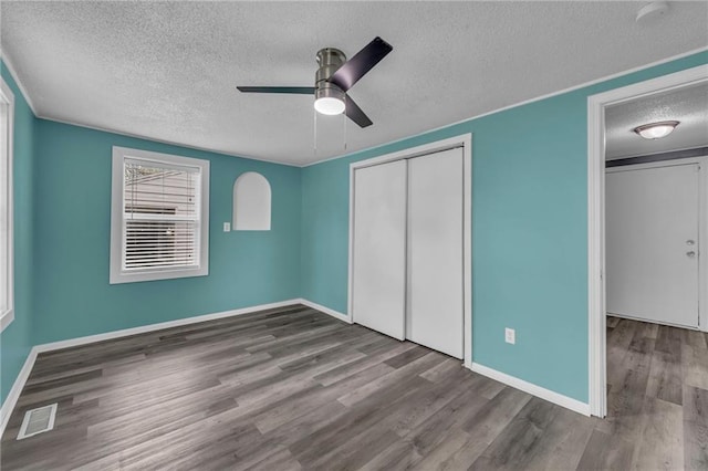 5315 Hardy Ave, Raytown, MO 64133 - unfurnished bedroom with a closet, visible vents, wood finished floors, baseboards, and a textured ceiling