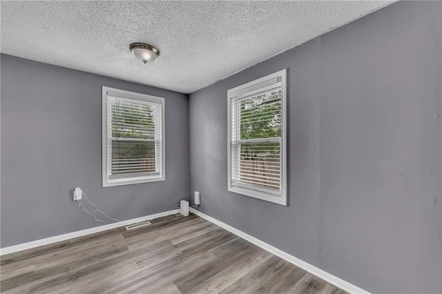 5315 Hardy Ave, Raytown, MO 64133 - spare room featuring a textured ceiling, baseboards, wood finished floors, and visible vents