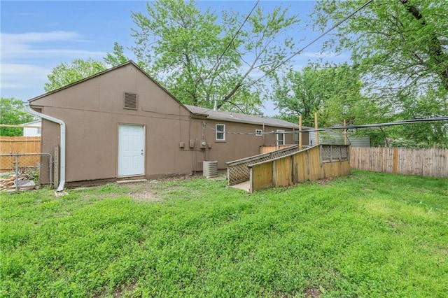 5315 Hardy Ave, Raytown, MO 64133 - rear view of property featuring a yard, a fenced backyard, and stucco siding