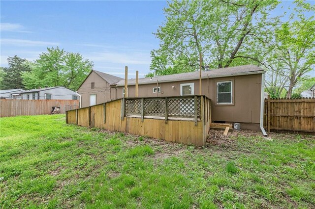 5315 Hardy Ave, Raytown, MO 64133 - back of property with a fenced backyard, a wooden deck, and a yard