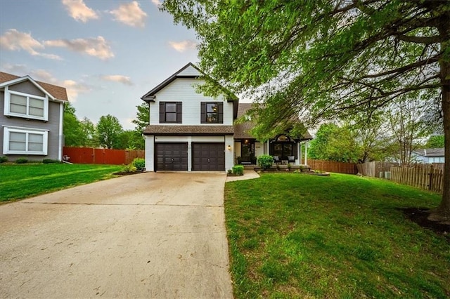 view of front facade with fence, an attached garage, driveway, and a front yard