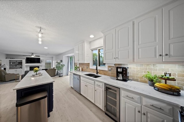 kitchen featuring a sink, dishwasher, a ceiling fan, open floor plan, and wine cooler