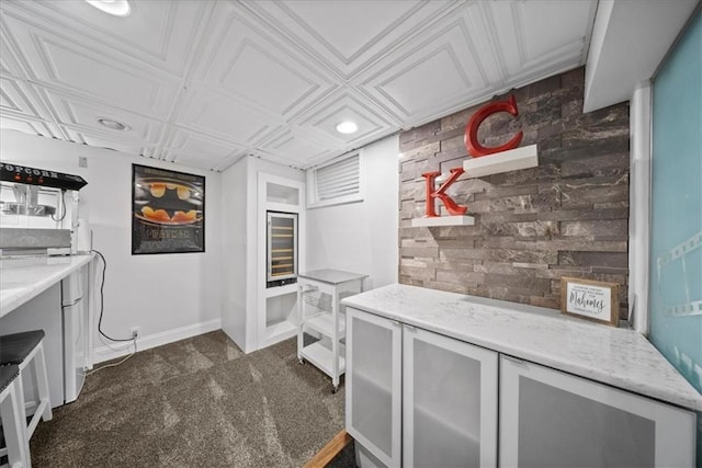 interior space with baseboards, an ornate ceiling, light stone counters, recessed lighting, and dark carpet
