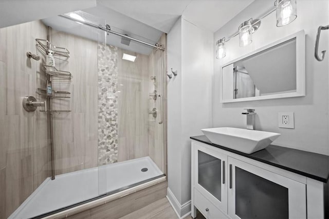 bathroom featuring vanity, a stall shower, and wood finished floors