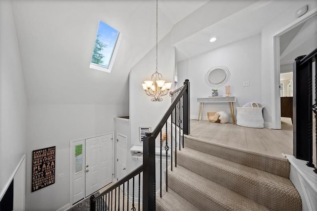 staircase featuring recessed lighting, baseboards, a chandelier, and vaulted ceiling with skylight