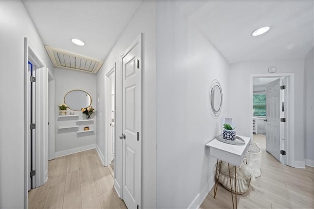 corridor with light wood-style floors, baseboards, recessed lighting, and visible vents