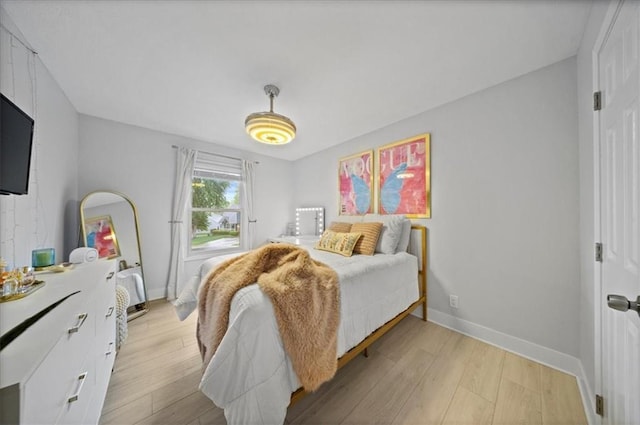 bedroom featuring light wood-style floors and baseboards