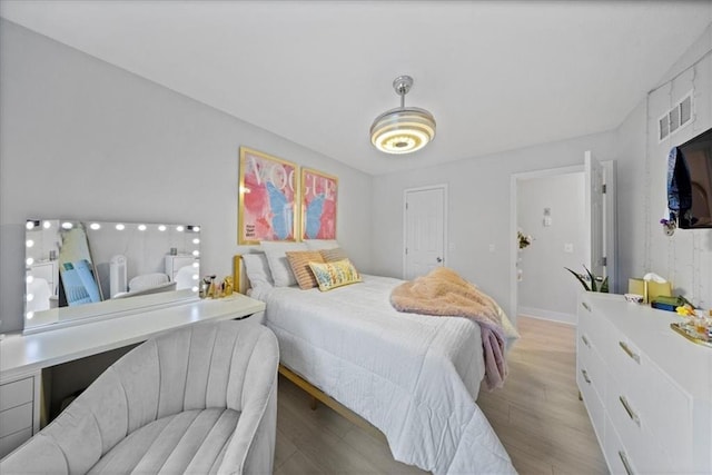 bedroom with light wood-style floors and visible vents