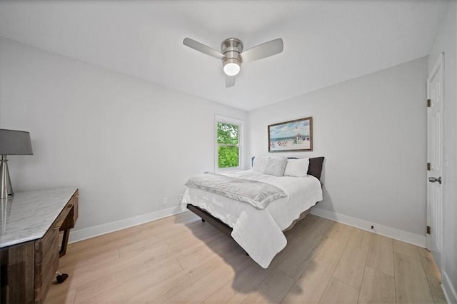 bedroom featuring a ceiling fan, baseboards, and light wood-type flooring